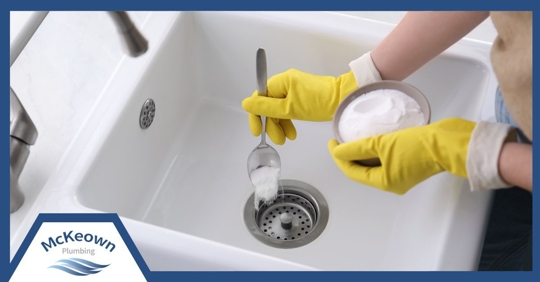 a woman adding baking soda down the drain