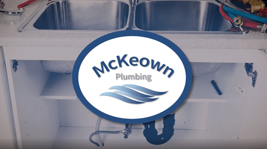 logo of McKeown Plumbing in front of kitchen sink