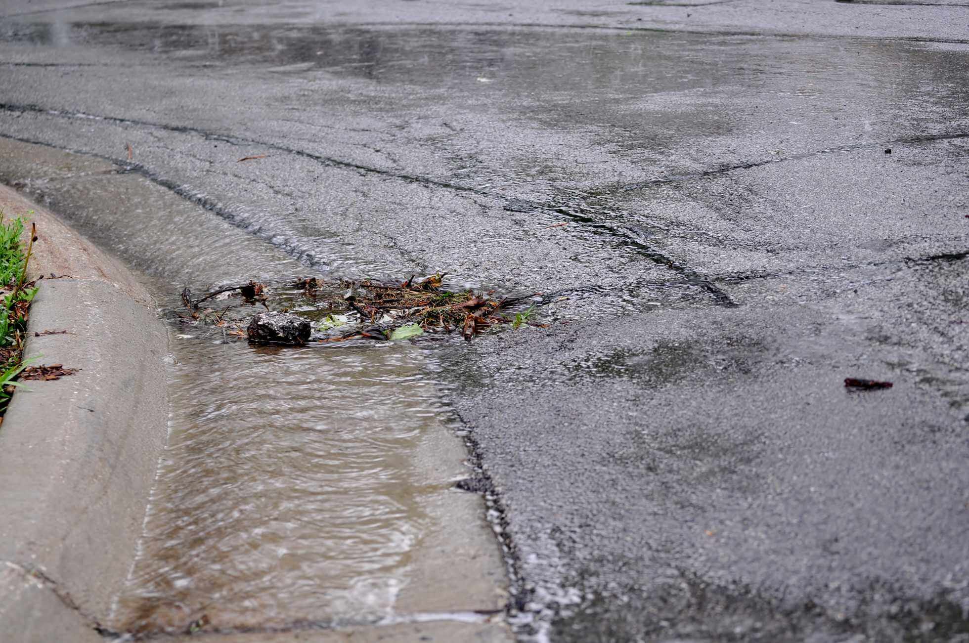 Blocked street sewer with overflowing water