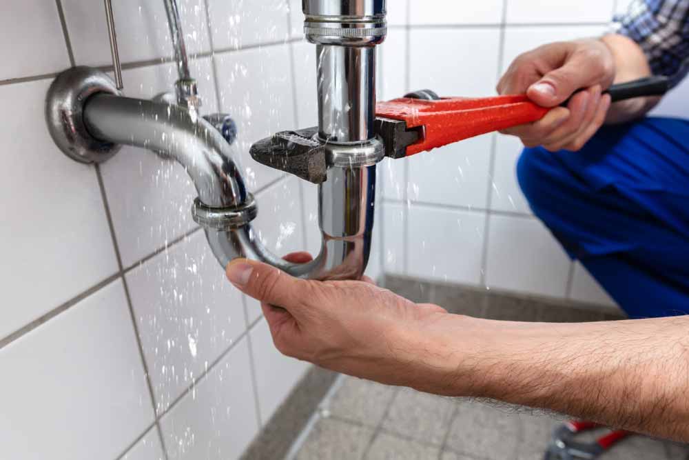 Man Fixing Leaking Pipe